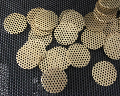 Lots of perforated filter disc are placed together.