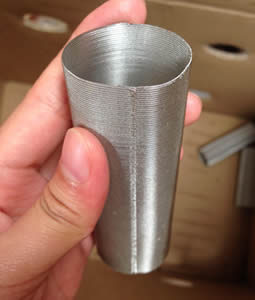 Five fingers pinch a galvanized seam welding filter tube.