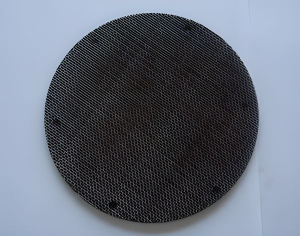 A round black wire cloth filter disc with spot welding.