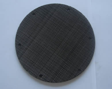 A round spot welding black wire cloth filter disc.