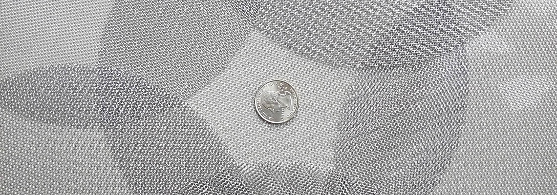 Several piece of stainless steel filter discs are placed together with a metal coin in the middle formed a flower shape.