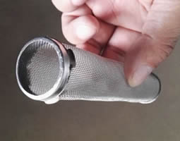 A hand holds a oblique cylinder filter.