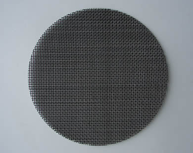 A round black wire cloth woven filter disc.